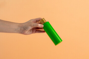 Green shampoo bottle in hand isolated on cream background