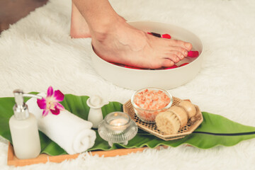 Woman indulges in blissful foot massage at luxurious spa salon while masseur give reflexology therapy in gentle day light ambiance resort or hotel foot spa. Quiescent