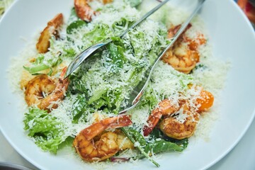 A plate of shrimp and salad with a lot of cheese