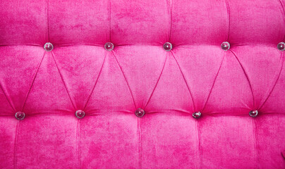 A pink couch with a pink cushion and a pink pillow