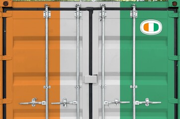 Ivory Coast flag depicted on metal doors of shipping cargo container outdoors in docks area close up