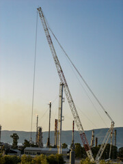 Fototapeta premium Refinery Under Construction with Heavy Machinery and Building Materials