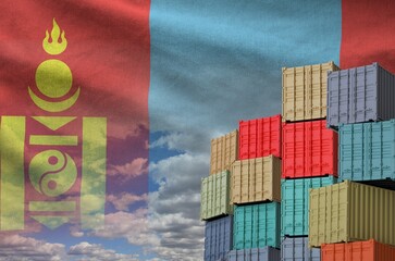 Mongolia flag and big stack of shipping cargo containers in docks with sky background close up