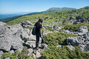 Naklejka premium Traveler Woman standing on a rocks in the summer mountain .Vitosha Mountain ,Bulgaria 