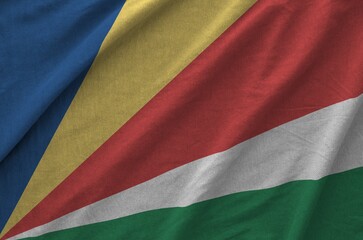 Seychelles flag depicted on folded wavy fabric of old cloth close up