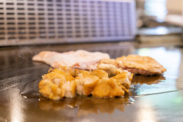 The chef is stirring the delicious Teppanyaki chicken and the aroma is overwhelming