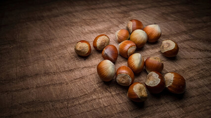 Hazelnuts in shells on a wooden board.