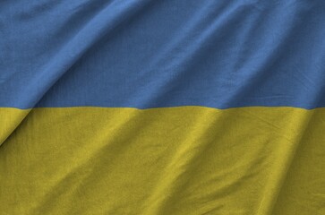 Ukraine flag depicted on folded wavy fabric of old cloth close up