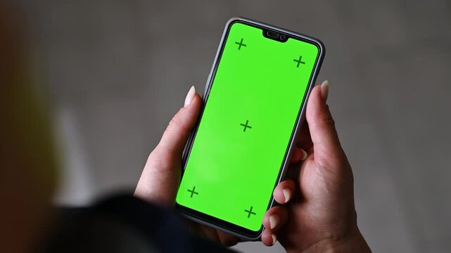 Girl Holding A Smartphone With A Greenscreen And Tracking Markers