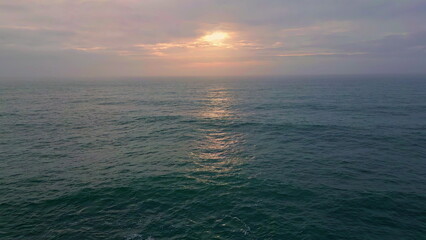 Fototapeta premium Cloudy evening sky ocean water rippling waving in slow motion. Marine horizon