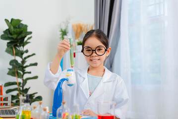 young Asia girl Scientist Conducting Experiment With Microscope In Laboratory