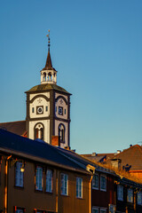 Fototapeta premium Sunset rays illuminate the charming landscape of Roros, featuring the town's landmark church and wooden architecture