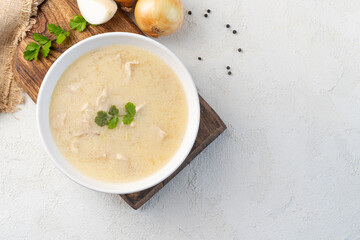 Chikhirtma - Georgian traditional chicken soup in the white plate and ingredients, flat lay, copy space