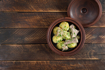 Stewed potatoes with meat, onions and herbs in a jug