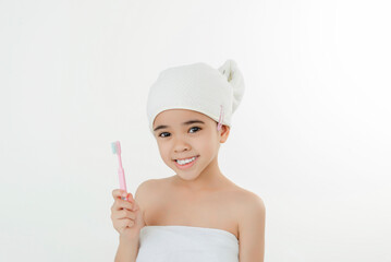 Smiling Child Brushing Teeth in Bathroom With Towel Wrap