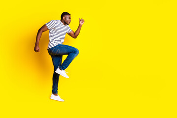 Full body portrait of nice young man jump run empty space wear t-shirt isolated on vibrant yellow color background