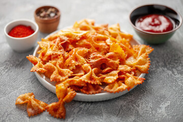 Homemade Trendy Pasta Chips. Crispy Spicy Pasta Farfalle with Tomato Sauce.