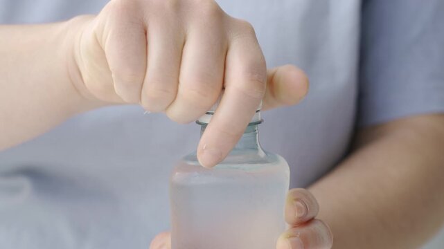 Close up of female hand pain while opening Plastic Bottles of water.Concept of no stuck cap when opening a bottle of water