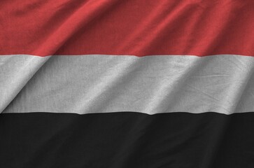 Yemen flag depicted on folded wavy fabric of old cloth close up