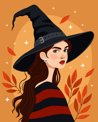 Portrait of a young woman wearing a black witch hat and a red sweater. Witch, sorceress. Halloween, samhain. Brunette with green eyes. Orange background. Autumn october leaves.