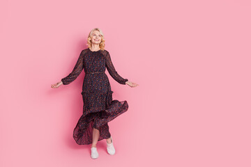 Full length portrait of nice aged lady dance look empty space wear dress isolated on pink color background