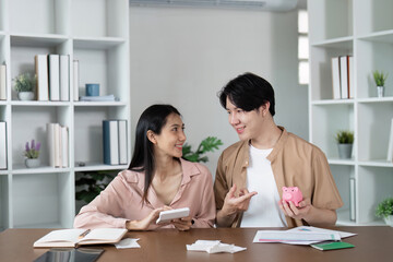 Fototapeta premium Young Couple Discussing Savings and Financial Planning with Piggy Bank and Documents in Modern Home Office