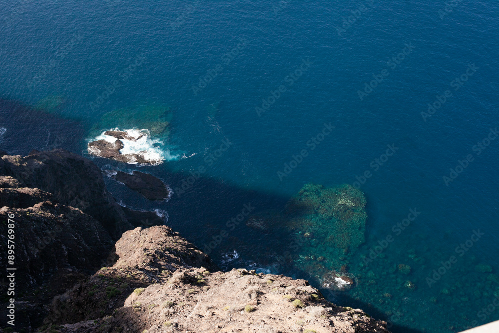 Wall mural aerial view of blue sea or ocean and rocks, looking down from top of the cliff or mountain, horizont