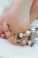 Anklet bracelet on a bare foot. Modern fashion style jewelry. Relaxing, vacations. Boho style
