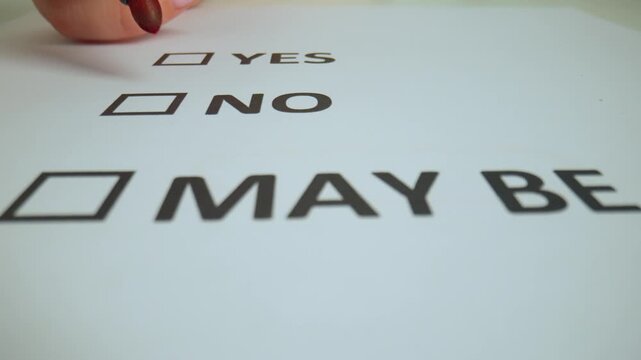 Close up shot of woman hand working with document, red marker in female hand writing check mark in text box with word no in document.