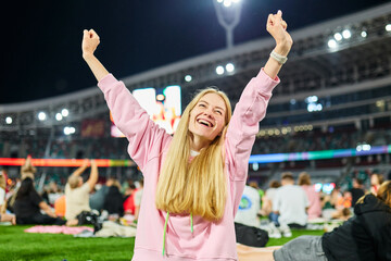 Young female fan rejoices after scoring a goal while watching a live broadcast of the championship