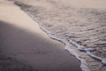A detailed view of a wave breaking on a sandy shoreline