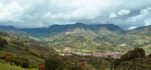 Obraz premium Cityscape of Jardin, Jardín, Antioquia, Colombia. Awesome landscape with the green Andes Mountains and a dramatic cloudy sky.