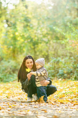 Mother and child explore autumn leaves