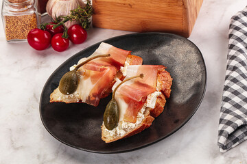 Bruschetta with jamon and caper berries