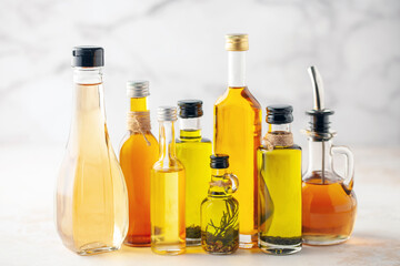 Various vegetable and seed oil in bottles on a bright background.