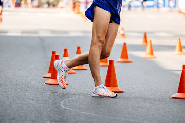 racewalking track, athlete legs, makes a turn around red safety cones