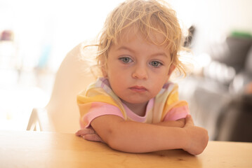 blond baby close up. baby one year old with blue eyes. thinking and a little bit sad. 