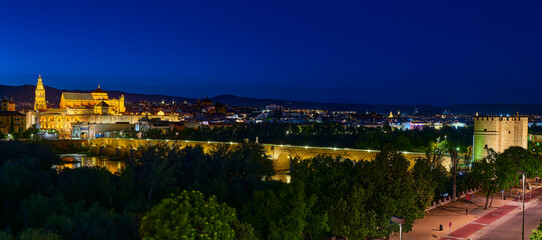 Night panoramic view of the Mosque-Cathedral across the Calahorra Tower and the Roman Bridge over the Guadalquivir River, Cordoba, Andalusia, Spain.