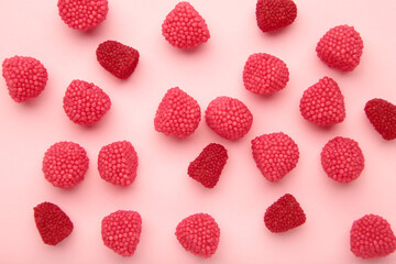 Red chewing sweets in the form of berries. Sweets in the form of raspberries on pink background....