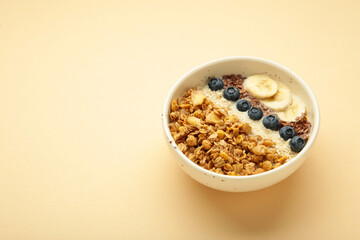 Granola with fresh summer berries in a bowl on beige background. Concept of healthy breakfast food