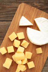 Parmesan cheese with camembert on cutting board. Vertical photo