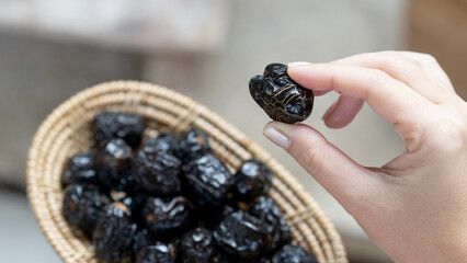Close-up of woman's hand holding dried Ajwah dates that Muslims eat to break their fast in Ramadan.