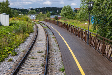 An empty railway track turning left along a station platform