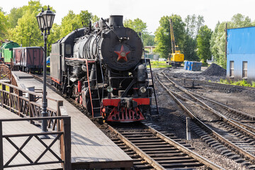 Retro passenger train with black steam locomotive from USSR times