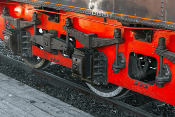 Wheels and red details of vintage black steam locomotive,
