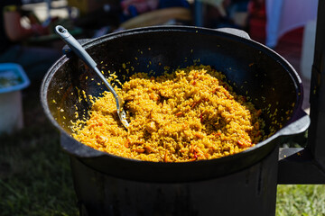 Rice with carrots, meat and spices when cooking pilaf in a cauldron
