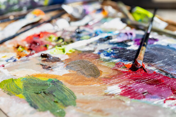 Fototapeta premium Artist's palette, close-up. Selective focus on the foreground. Background image