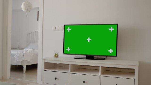 Woman going to the bedroom passing television from living room. Pregnant female walking in the room. Domestic Cinema concept, television with chroma key.