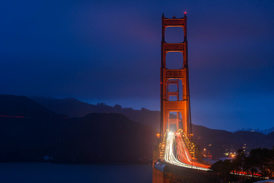 View of Golden gate bridge with light trails lef tby passing vehicles at twilight in autumn