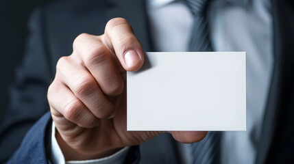 Businessman Showing Blank White Business Card: Close-up of a businessman's hand displaying a blank white business card.